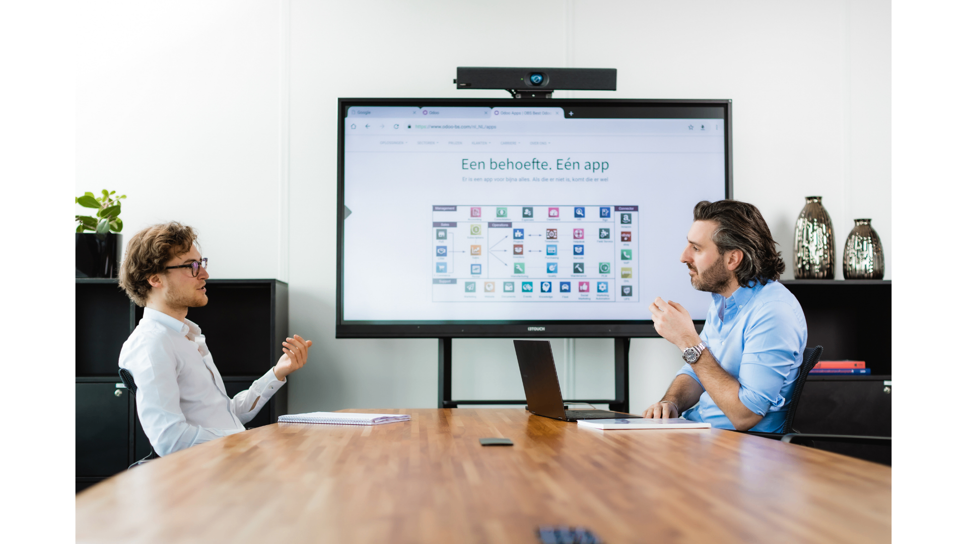 Twee OBS-consultants bespreken de Odoo-app-strategie voor een Belgische KMO in de vergaderzaal