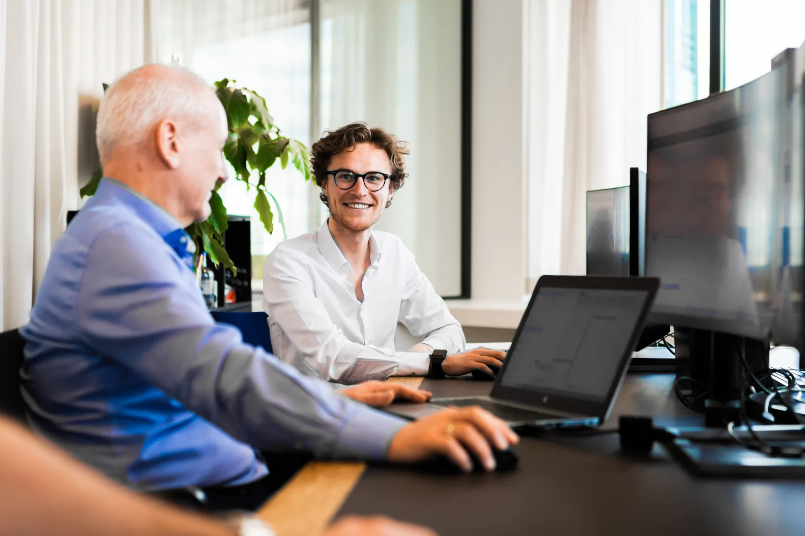 Twee OBS Solutions consultants bekijken samen een Odoo-scherm tijdens een migratietraject