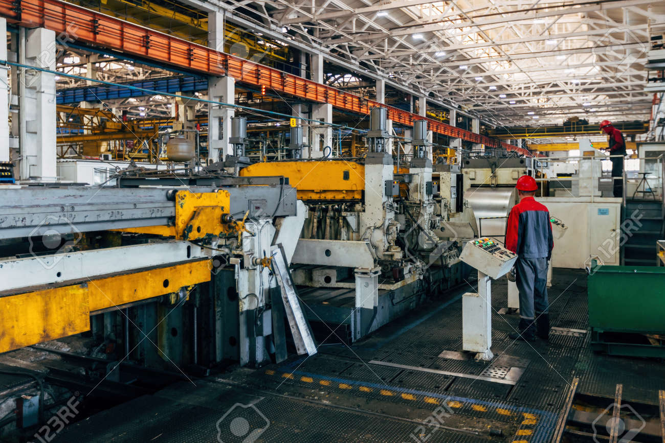Productiemedewerker bedient machines in een industriële productiehal